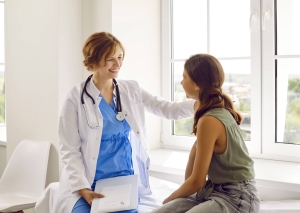 Smiling school nurse consoling a female student