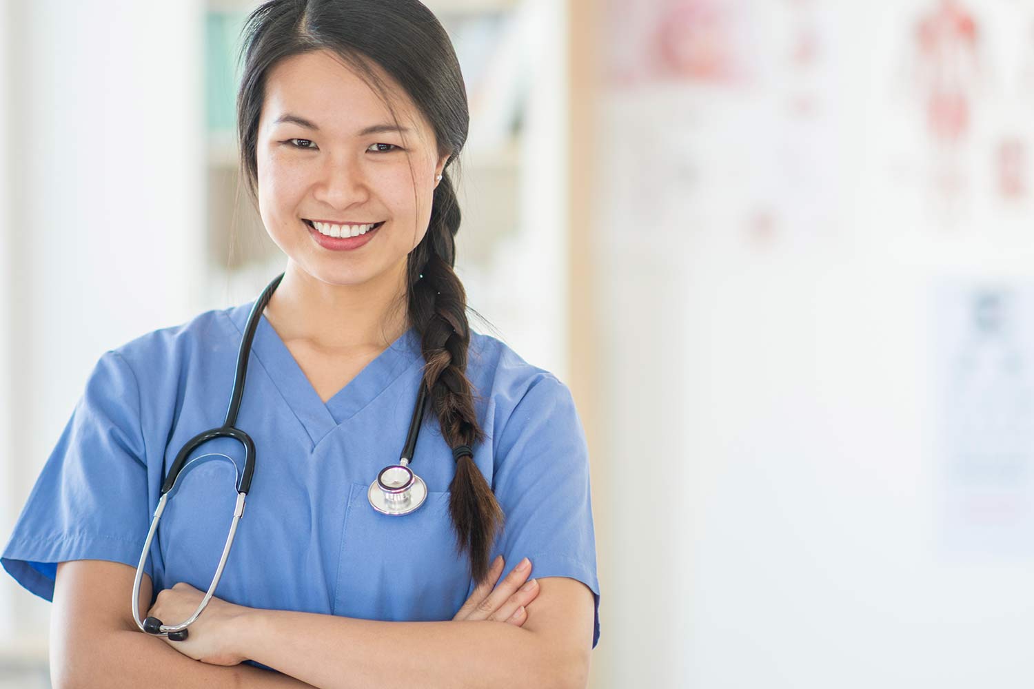 Asian nurse smiling with her arms crossed